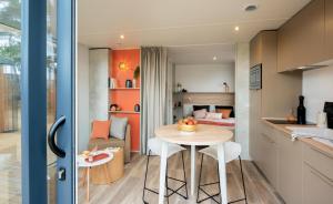 a small kitchen and dining room with a table and chairs at Camping Le Parc de Paris in Villevaudé
