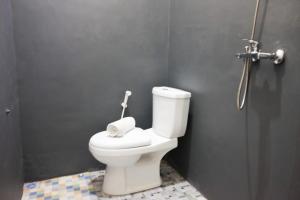 un bagno con un water bianco in una cabina di RedDoorz Syariah near Exit Tol Pemalang Comal 2 a Comal
