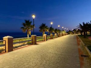 a sidewalk with street lights and the ocean at night at Alba Radiosa in Santa Caterina Dello Ionio Marina