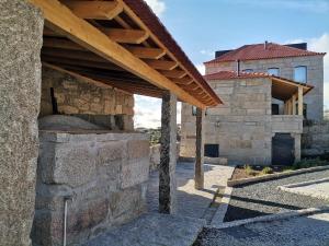 un bâtiment en pierre avec un toit en bois et un four en pierre dans l'établissement Casa Nova Rural, à Nelas