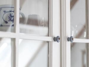 eine Tür mit einer blauen und weißen Tasse an einem Fenster in der Unterkunft Zum Felde Ferienwohnungen in Neustadt in Holstein