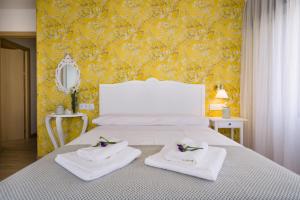 a bedroom with a white bed with towels on it at Pensión Ferradura in Melide