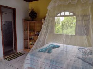 ein Schlafzimmer mit einem Bett mit Moskitonetz in der Unterkunft Suite d'Artistes in Imbassai