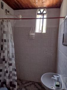 ein Badezimmer mit Waschbecken und Duschvorhang in der Unterkunft Suite d'Artistes in Imbassai