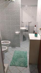 uma casa de banho com um lavatório, um WC e um tapete verde em Rifugio del marinaio em Milazzo