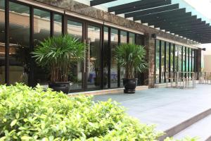 budynek z roślinami doniczkowymi poza nim w obiekcie Thomson Hotel Huamark w mieście Bangkok
