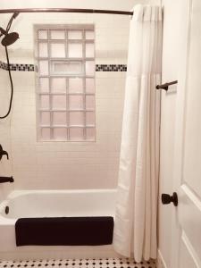 a bathroom with a white tub and a window at Logan Square Modern Apartment in Chicago