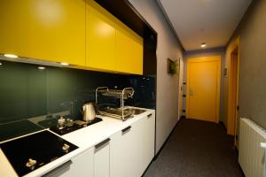 eine Küche mit weißen Schränken und einer gelben Tür in der Unterkunft Alliance Villa Gоderdzi in Khulo + 34 Fotos