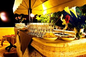 un tavolo con bicchieri da vino e ciotole di cibo di Hotel Ara Solis a Lido Azzurro