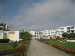 Une rangée d'immeubles d'appartements blancs avec des fleurs au premier plan dans l'établissement Condominio Las Terrazas, à Asia