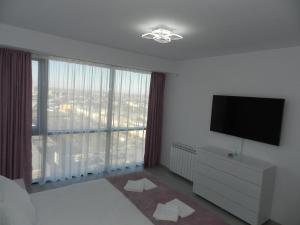 a bedroom with a flat screen tv and a large window at AP RELAX Tulcea in Tulcea