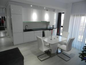 a kitchen with a white table and white chairs at AP RELAX Tulcea in Tulcea