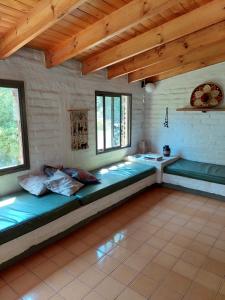 a room with long beds in a room with wooden ceilings at Cabaña de montaña in Potrerillos
