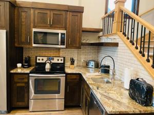 a kitchen with a stove top oven and a microwave at Cable Mountain Lodge in Springdale