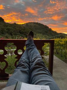 a person laying on a bench looking at the sunset at Belcruz family lodge in Monteverde Costa Rica