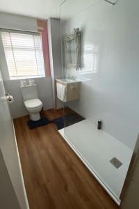 ein Badezimmer mit einem WC, einem Waschbecken und einem Spiegel in der Unterkunft Beach View Cottage in Isle of Gigha