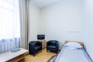 um quarto com uma cama, 2 cadeiras e uma secretária em Hotel Zvezda em Tiumen
