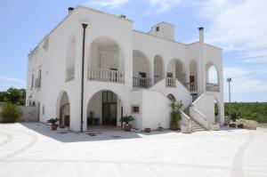 a large white building with a staircase in front at Masseria Cappella in Martina Franca