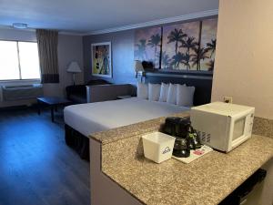 a hotel room with a bed and a television at Days Inn by Wyndham Indio in Indio +35 photos