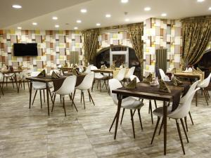 un restaurant avec des tables et des chaises et une télévision dans l'établissement Feyzan Hotel, à Çorum