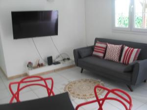 a living room with a couch and a flat screen tv at PETIT PARADIS in Quartier Morne la Valeur