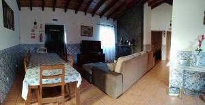 a living room with a table and a couch at A Casa da Formosinha in Madalena