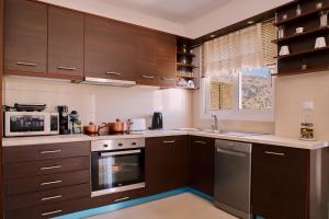 a kitchen with brown cabinets and a stove top oven at Lake View Suites in Kávallos