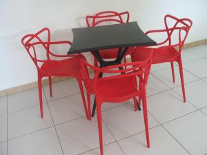 a table and four red chairs in a room at PETIT PARADIS in Quartier Morne la Valeur