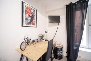 a room with a desk with a bike on it at Studio cosy au cœur du centre ville in Mâcon