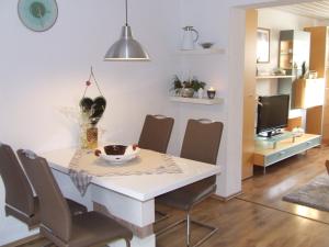 a dining room with a white table and chairs at Ferienwohnung Hochwald - im Herzen des Saarlandes in Quierschied