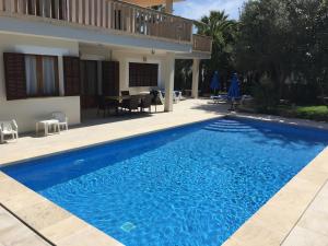 uma piscina azul em frente a uma casa em Villa Antonia em Sa Coma