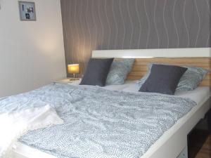 a bedroom with a bed with a blue comforter and pillows at Ferienwohnung Hochwald - im Herzen des Saarlandes in Quierschied