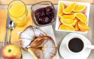 a table with a plate of bread and oranges and a cup of coffee at The Stone Forest in Kalabaka