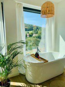 a bath tub in a bathroom with a large window at Karkonosze. Tuż nad ziemią. in Staniszów +11 photos