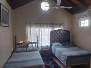 a bedroom with two beds and a window at Dancehall Hostel in Kingston