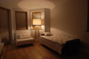 une chambre avec un lit, une lampe et une chaise dans l'établissement TLA Schreiberhau, à Szklarska Poręba