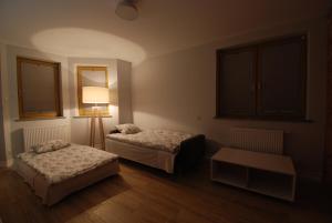 Cette chambre comprend deux lits, une lampe et une table. dans l'établissement TLA Schreiberhau, à Szklarska Poręba