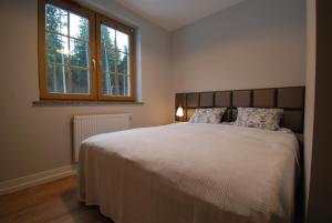 une chambre avec un grand lit et une fenêtre dans l'établissement TLA Schreiberhau, à Szklarska Poręba