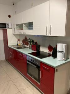una cocina con electrodomésticos rojos y armarios blancos en Hostel Ellwürder Hof en Nordenham
