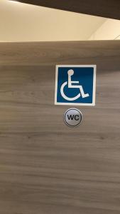 a sign on a door with a wheelchair sign on it at Hostel Ellwürder Hof in Nordenham