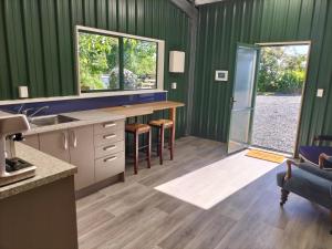 a kitchen with green walls and a counter with a sink at Karamu Homestead in Karamu