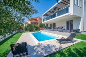 a swimming pool in the backyard of a house at Wonderhouse SOVLJA in Tribunj