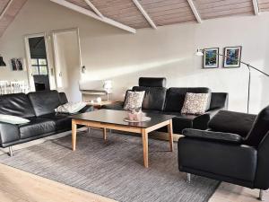 sala de estar con muebles de cuero negro y mesa de centro en 6 person holiday home in H jslev, en Højslev