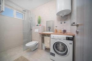 a bathroom with a washing machine and a sink at Wonderhouse SOVLJA in Tribunj