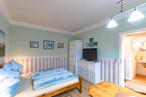 a small bedroom with a bed and a television at Vergissmeinnicht Studio 2 in Ostseebad Sellin