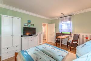 a living room with a bed and a television at Vergissmeinnicht Studio 2 in Ostseebad Sellin