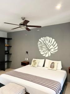 - une chambre avec un grand lit et un ventilateur de plafond dans l'établissement Maya Eco Village, à Akumal