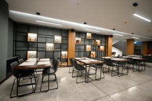 ein Esszimmer mit Tischen, Stühlen und Lichtern in der Unterkunft Alliance Villa Gоderdzi in Khulo