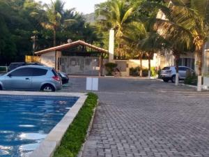 Un coche aparcado delante de una casa con palmeras. en Casa de praia em condomínio fechado Juquei, en São Sebastião