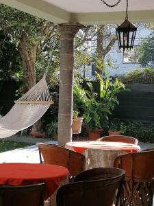 un patio con mesas y sillas y una hamaca en Casa de Luz, en Guadalajara